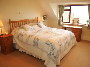 Un dormitorio con una cama grande y una ventana. en Overwater Lodge, en Bassenthwaite Lake