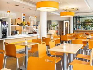 an empty restaurant with tables and chairs at ibis budget Tours Nord in Tours
