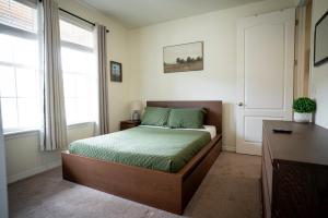 een slaapkamer met een bed, een bureau en ramen bij Stylish Retreat in Parker Near Hwy, Parks & Dining in Parker