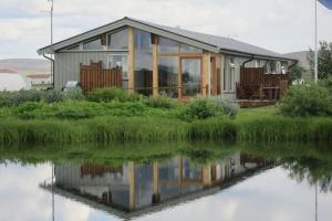 una casa junto a un cuerpo de agua en Grímsstaðir Guesthouse en Grímsstaðir á Fjöllum