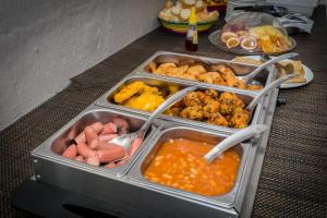 a table with several trays of food on a table at EvaZion River Side in Grande Rivière Sud Est +36 photos