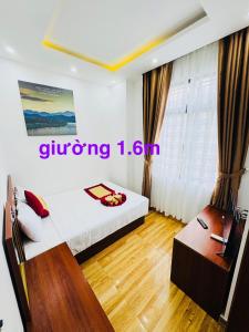 a room with a bed and a desk in it at Sapphire HOTEL HUE in Hue