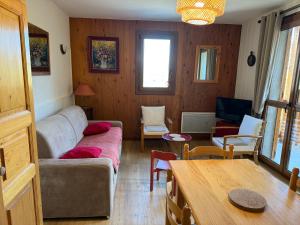 una sala de estar con un sofá y una mesa en T2 les Marguerites, en Enchastrayes