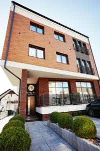 a brick building with a car parked in front of it at Madera apartments in Čačak