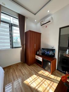a living room with a tv and a desk with a tvictericter at Sapphire HOTEL HUE in Hue