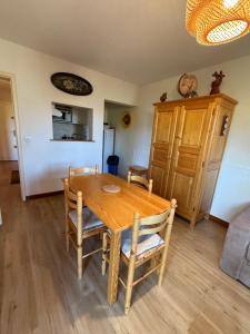 Un comedor con mesa y sillas de madera. en T2 les Marguerites, en Enchastrayes