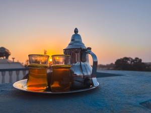 a tea kettle and two glasses on a plate at Freebird Surfcamp Morocco in Agadir