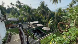 a balcony of a house with a pool and palm trees at Balai Halang in Palavit