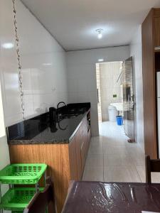 a kitchen with a counter and a sink and a bathroom at apartamento lindo com 2 quartos in Itapoa +13 photos