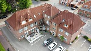 a large house with a car parked in a parking lot at Hotel Sophien-Café in Leer