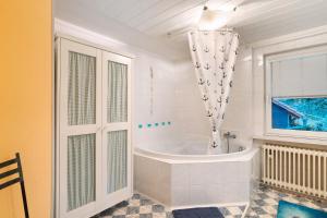a white bathroom with a tub and a window at Ferienwohnung Spiritbalance in Sasbachwalden +31 photos