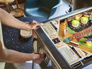 a man playing a pinball game on a machine at Greet Hotel Paris porte de la Chapelle - Aréna in Paris +23 photos