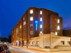 a building with a blue sign on the side of it at Ibis Budget Lille Gares Vieux-Lille in Lille