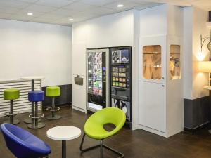 a room with chairs and a soda machine at Ibis Budget Lille Gares Vieux-Lille in Lille