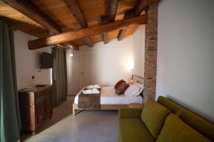 a bedroom with a bed and a couch in a room at Dimora Lincoln in Grotte