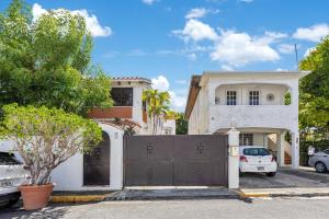 a house with a gate in front of a garage at Beach Pad w Patio, walk to everything! GEN AC - 20 Down in San Juan