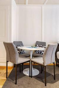 une table avec quatre chaises et une table blanche dans l'établissement City Center Apt With AC in Zurich Old Town, à Zurich