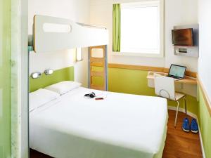 a bedroom with a bed and a desk with a laptop at ibis budget Sao Paulo Jardins in Sao Paulo +118 photos