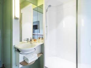a bathroom with a sink and a mirror at Ibis Budget Marmande in Marmande +42 photos