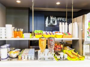 a kitchen with a counter with a blender and fruits at Ibis Budget Marmande in Marmande