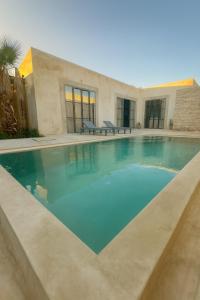 une piscine devant une maison dans l'établissement Villa Zina, à Ghazoua
