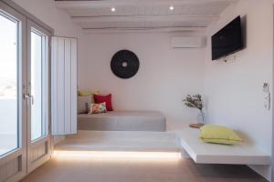 a room with a bed and a clock on the wall at Xerolithos Natural Living in Naxos Chora