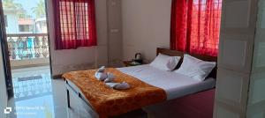Un dormitorio con una cama con dos animales de peluche encima. en RN guest house, en Arambol