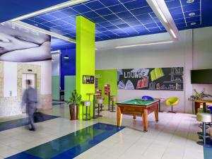 a man walking through a room with a ping pong table at ibis budget Belem in Belém