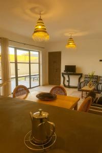 un salon avec une table, des chaises et des lumières dans l'établissement Villa Zina, à Ghazoua 7 autres photos