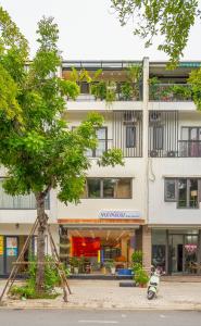 a tree in front of a building with a building at Leng x Vuishare - Ecopark with working space in Kim Quan