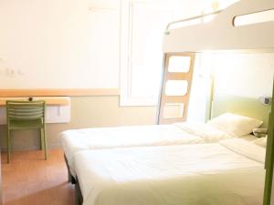 ein Hotelzimmer mit zwei Betten und einem Schreibtisch in der Unterkunft ibis budget Metz Sud in Augny