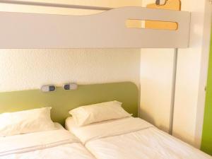 ein Etagenbett mit zwei weißen Kissen darauf in der Unterkunft ibis budget Metz Sud in Augny + 39 Fotos