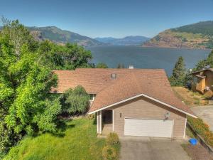 a house with a garage in front of a lake at Amber Sunset in Mosier