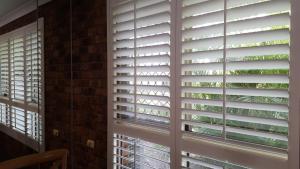a window with plantation shutters in a room at Ballina Palms Boutique Motel in Ballina