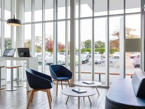 a room with two chairs and a table and windows at ibis Budget Auckland Airport in Auckland