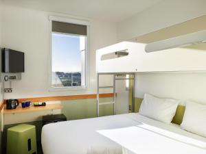 Un dormitorio con una cama blanca y una ventana. en ibis Budget Auckland Airport, en Auckland