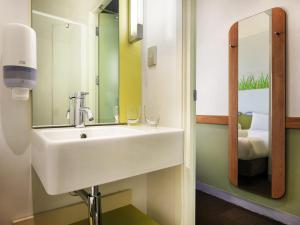 a bathroom with a sink and a mirror at ibis Budget Auckland Airport in Auckland +30 photos