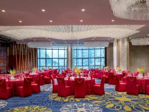 a banquet hall with red tables and chairs and windows at Sofitel Guiyang Hunter in Guiyang +66 photos
