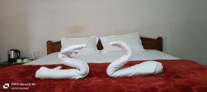Una cama con dos cisnes hechos de toallas. en RN guest house, en Arambol 4 fotos más