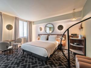 une chambre d'hôtel avec un lit et un miroir dans l'établissement Mercure Paris Opera Grands Boulevards, à Paris