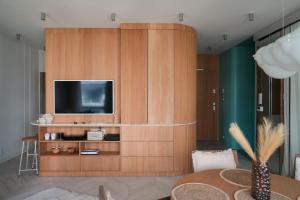 een woonkamer met een tv aan een houten muur bij Luxury Yacht Park Apartment Marina View Gdynia Free Parking in Gdynia