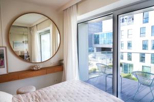 een slaapkamer met een spiegel, een bed en een balkon bij Luxury Yacht Park Apartment Marina View Gdynia Free Parking in Gdynia