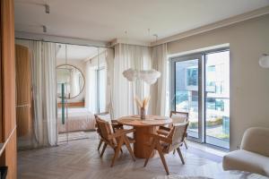 een eetkamer met een tafel en stoelen en een slaapkamer bij Luxury Yacht Park Apartment Marina View Gdynia Free Parking in Gdynia