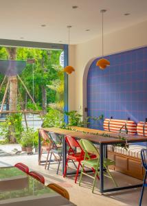 a dining room with a table and colorful chairs at Leng x Vuishare - Ecopark with working space in Kim Quan