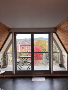 a room with a large glass window with a table at L'ALTÉA - top floor - bright - city center in La Roche-sur-Foron