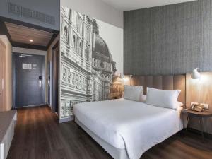 une chambre avec un grand lit blanc avec un tableau sur le mur dans l'établissement Mercure Firenze Centro, à Florence 95 autres photos