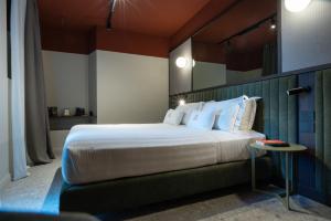 a hotel room with a large bed and a table at MÍMESIS 11 - Boutique Hotel in Como