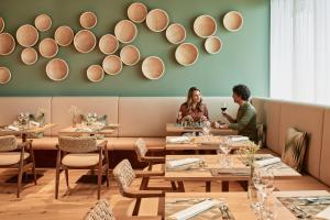 a couple sitting at a table in a restaurant at Falkensteiner Hotel Bad Leonfelden - Adults Only in Bad Leonfelden +28 photos