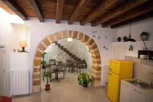 a kitchen with an archway and a table and chairs at Dimora Lincoln in Grotte