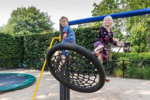 dos niños pequeños jugando en un patio de juegos en Park Berkenrhode, en Wekerom